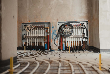 Radiant floor heating system installation with pipes and manifold