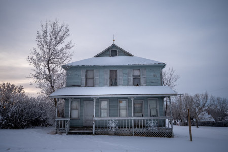 Old house covered in snow without heating during winter