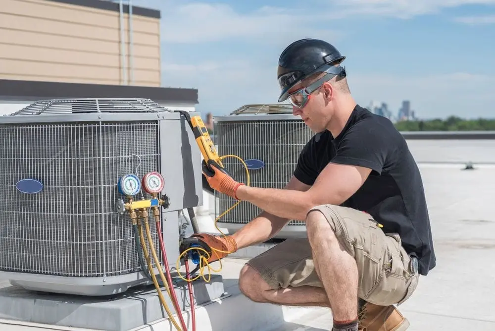 HVAC technician repairing HVAC unit during maintenance routine.