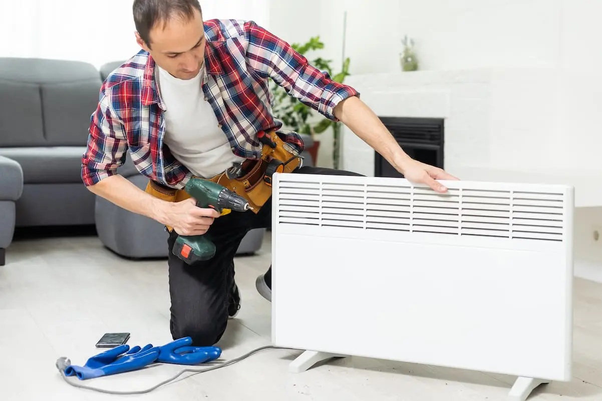 Technician fixing a home heater unit in a living room in El Paso
