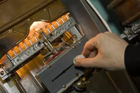 Performing maintenance on furnace by adjusting a knob.